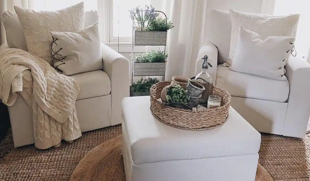 White loveseats and ottoman with farmhouse-style wicker decor