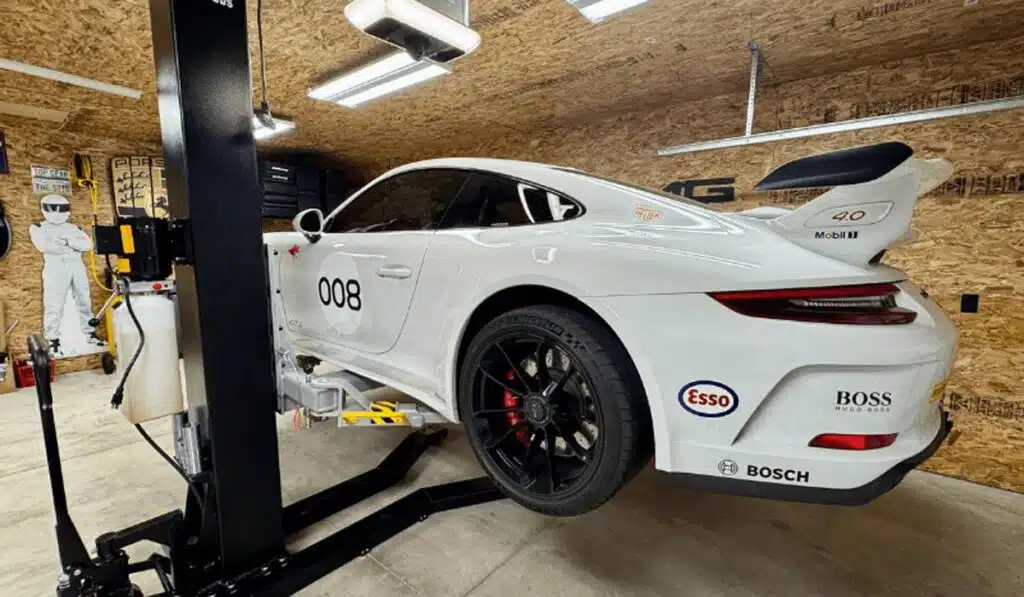 White Porsche 911 GT3 raised on single post lift