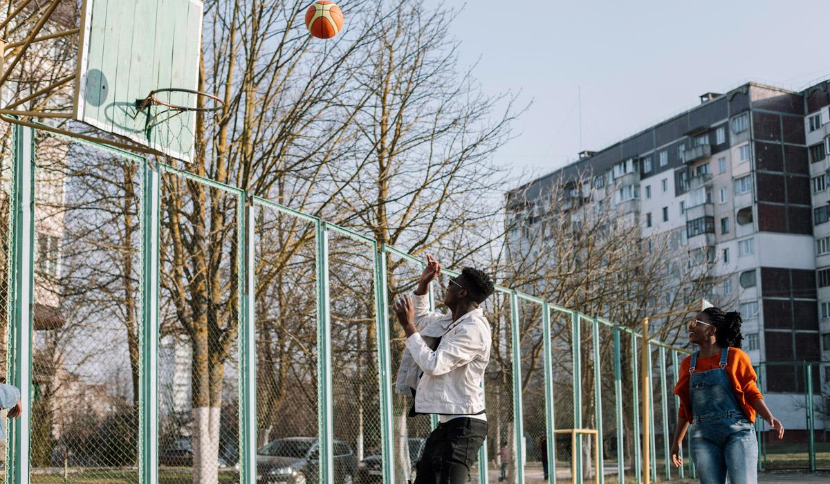 Young man shooting a basketball on an outdoor court