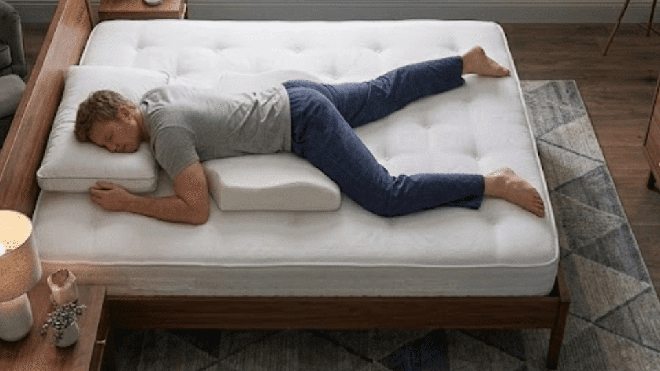 high angle shot of a man in pajamas sleeping on his stomach in a modern teal bedroom with a skyline view