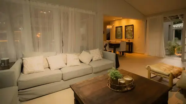 Cozy living room with beige sofa and wooden coffee table under warm lighting