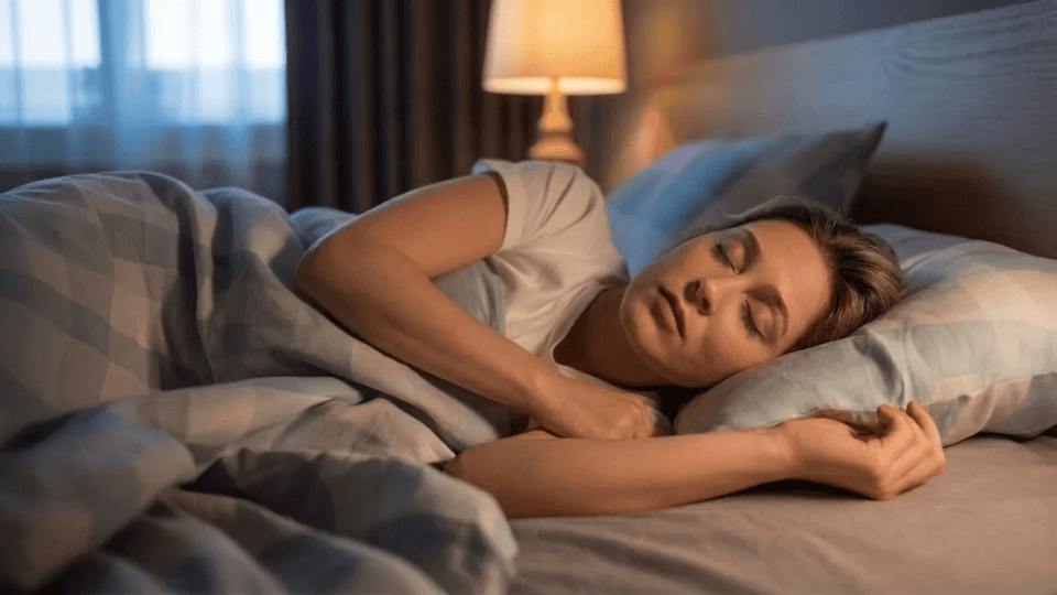 person lying on their back in bed at night, appearing restless and slightly uncomfortable while trying to fall asleep