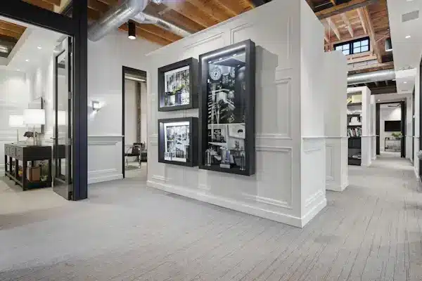 Contemporary office interior with white walls, framed artworks, and exposed wooden beams