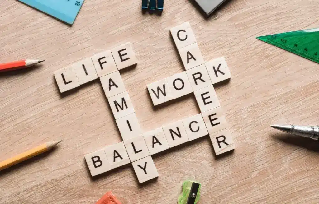 Wooden letter tiles forming words like "life," "work," and "balance" on a wooden surface