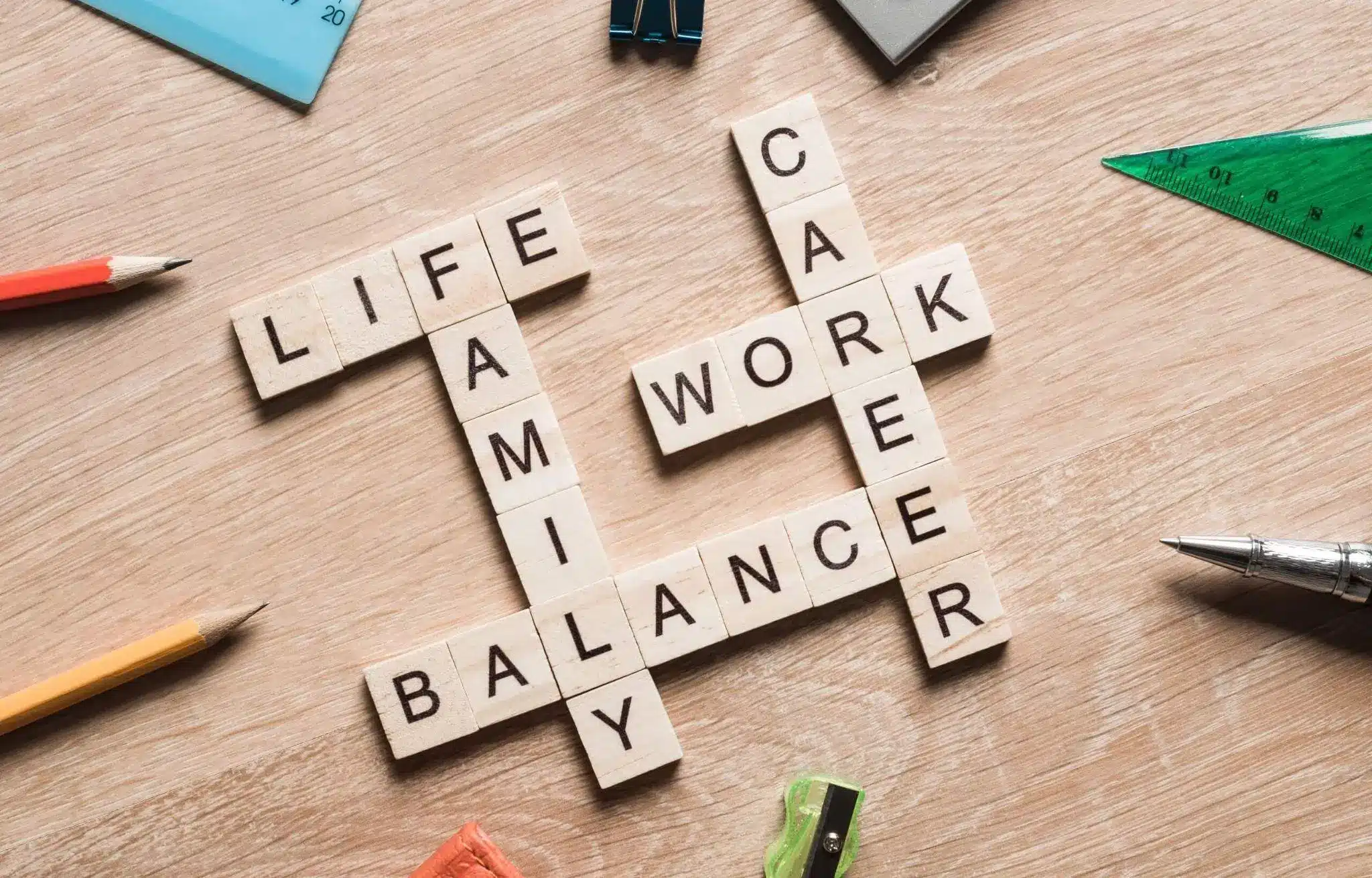 Wooden letter tiles forming words like "life," "work," and "balance" on a wooden surface