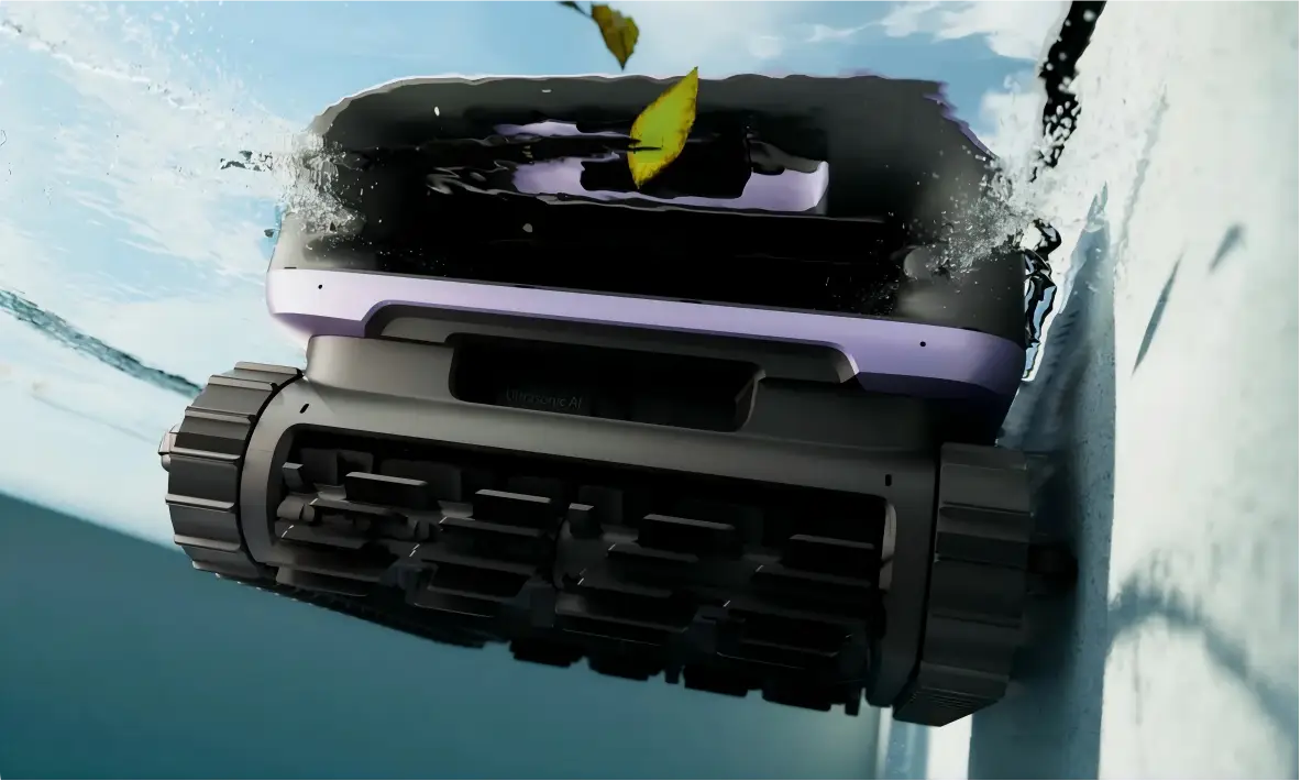 Robotic pool cleaner operating underwater with leaves floating above in bright daylight