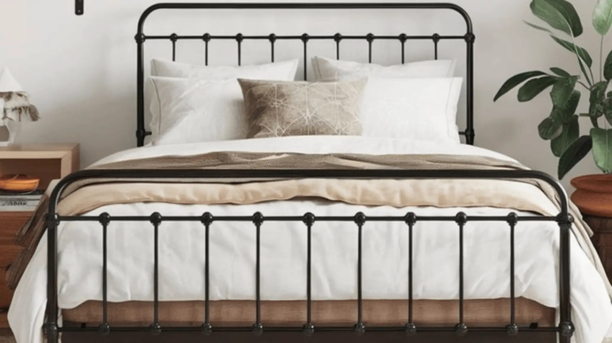 black metal bed frame with white bedding, neutral pillows, wooden nightstand, and potted plant in lit modern bedroom