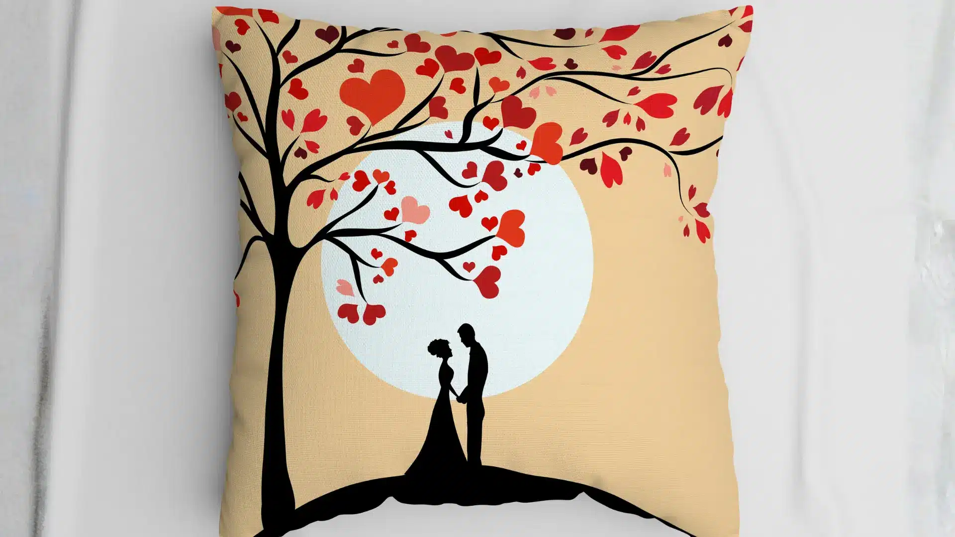 Decorative cushion featuring romantic silhouette couple under tree with heart-shaped leaves against soft sunset background, warm tones and minimal design