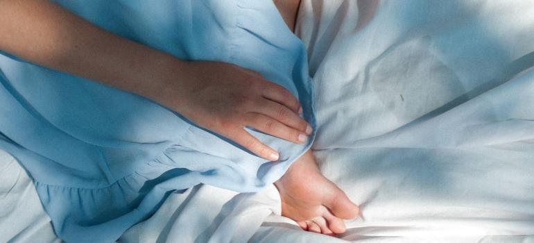 a hand and a foot on blue and white sheets
