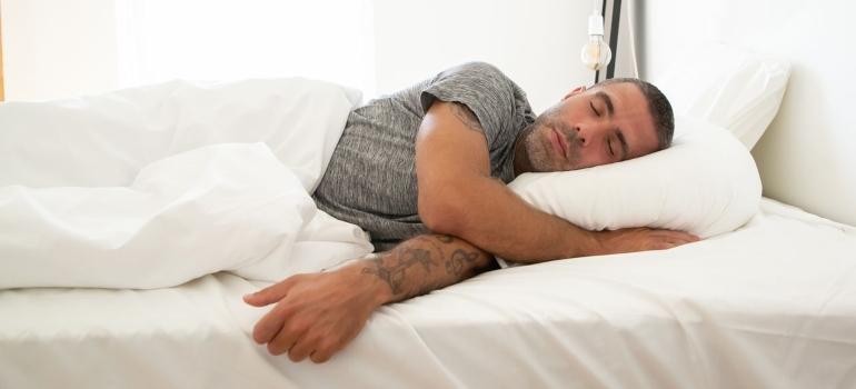 a man sleeping on white sheets