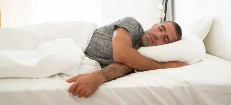 a man sleeping on white sheets