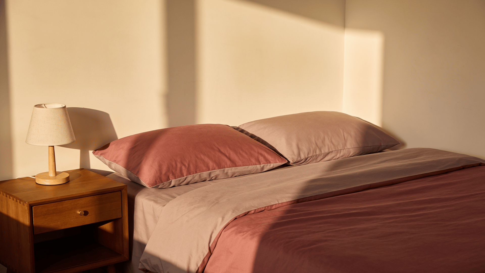 Warm toned sheets soften the bedroom palette