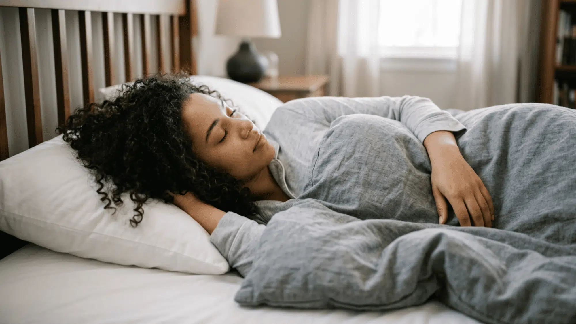 a women with dark curly hair sleeping on bed