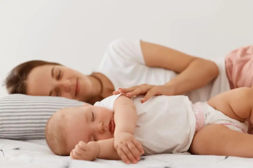 Mother and baby sleeping together in a cozy bedroom setting