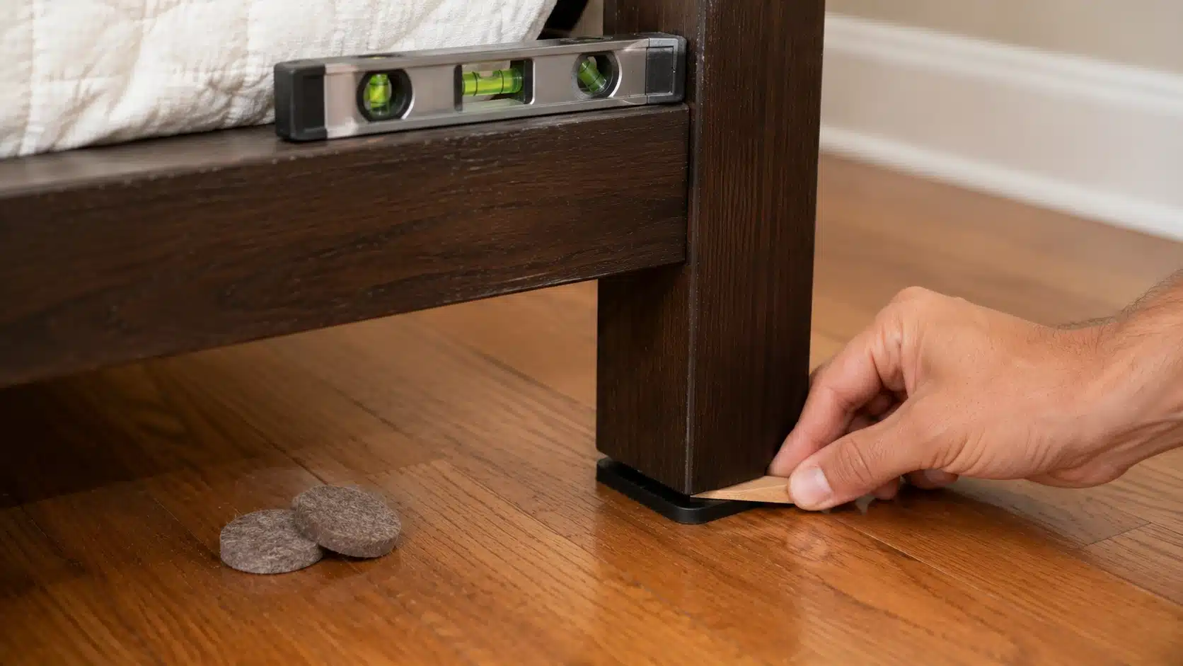 ubber floor pad and shim under a bed leg on hardwood floor to stop rocking and scraping