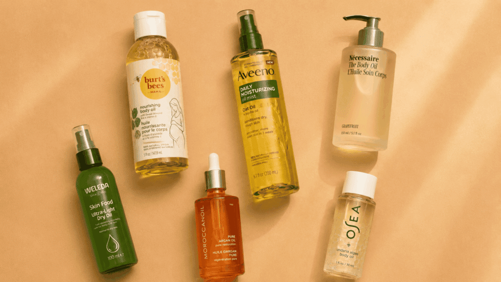 Flat lay of assorted body oil bottles surrounded by natural ingredients on a plain surface