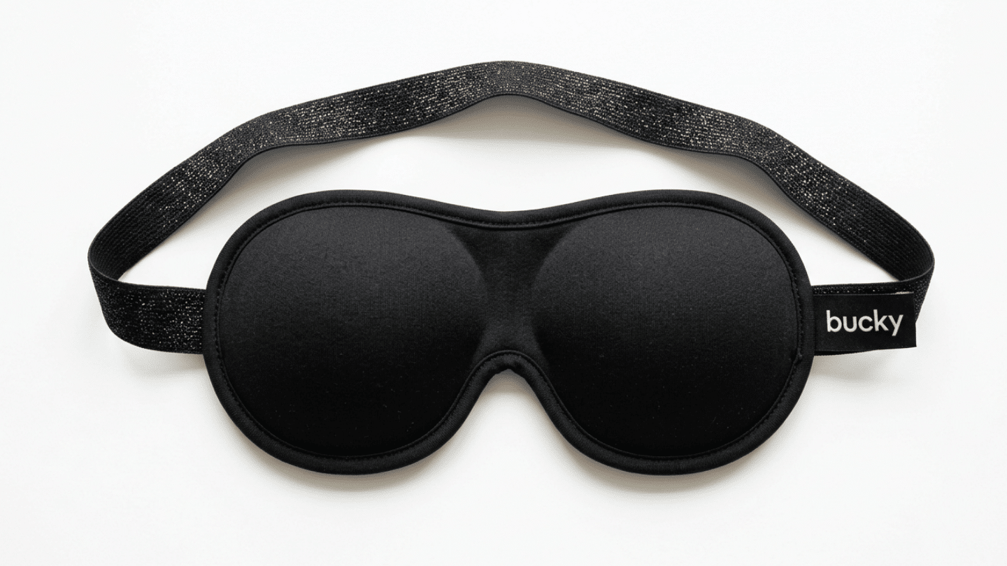 black Bucky contoured sleep mask with raised eye cups and a wide adjustable elastic strap on display