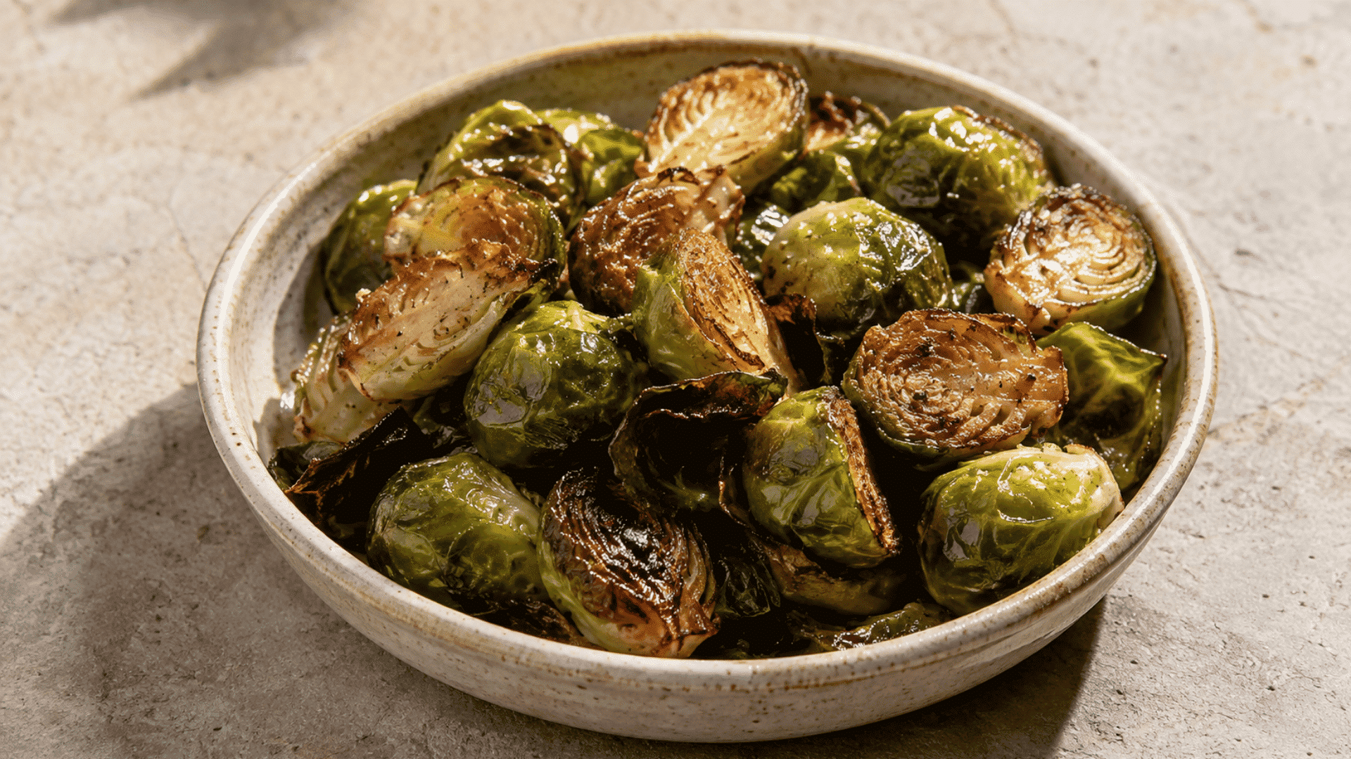 roasted Brussels sprouts with browned edges served in a ceramic bowl