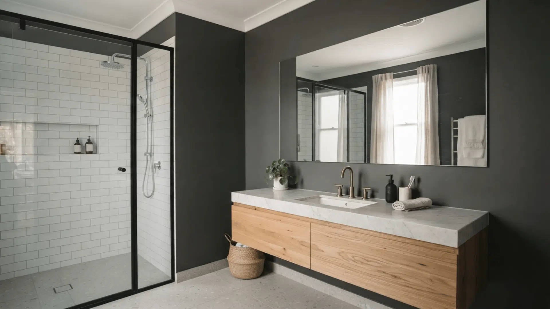 charcoal bathroom with wood vanity, white tiled shower, black frame, and large mirror