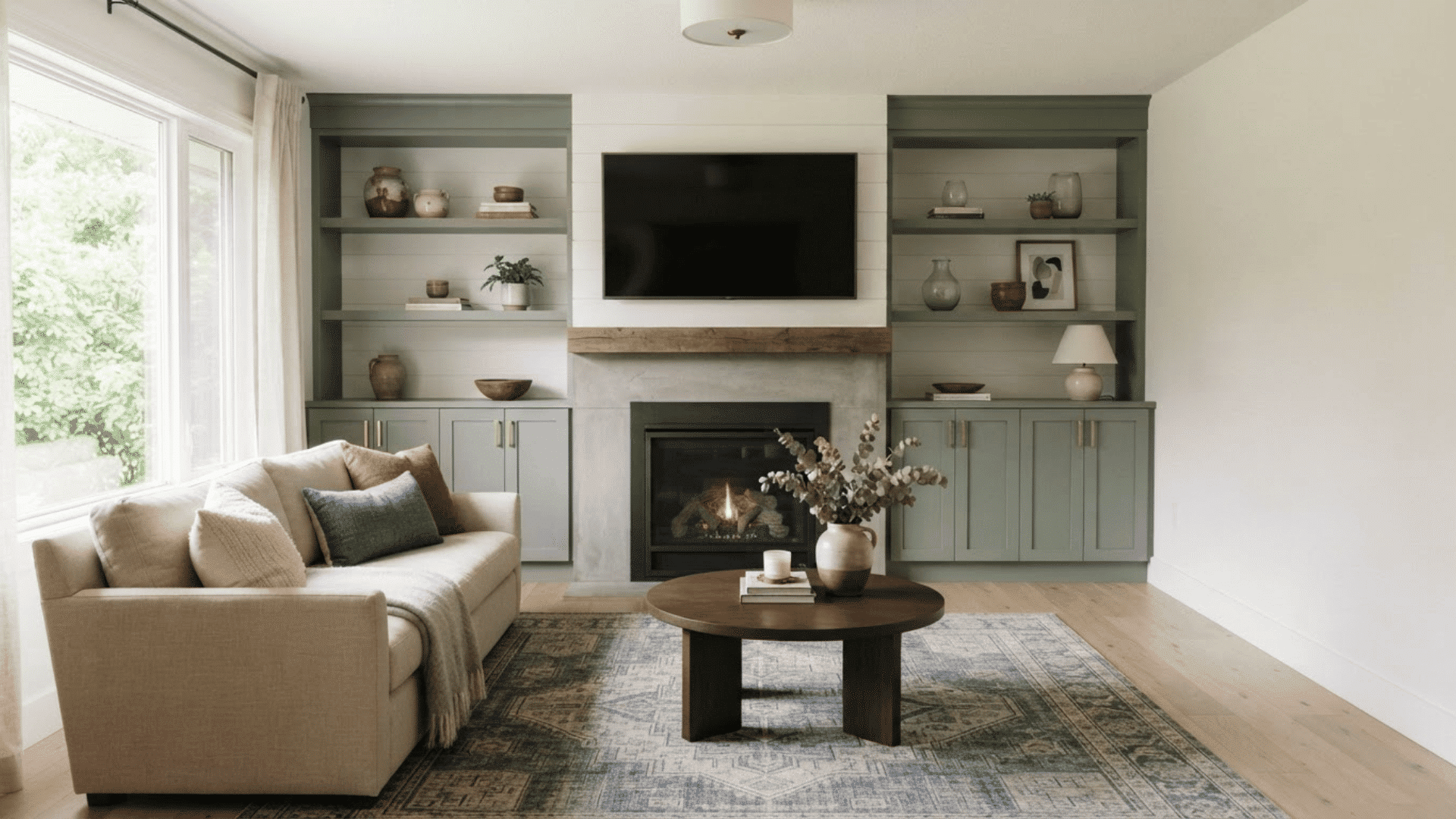 fireplace and TV wall with built-in shelves, cabinets, neutral sofa, and wood coffee table