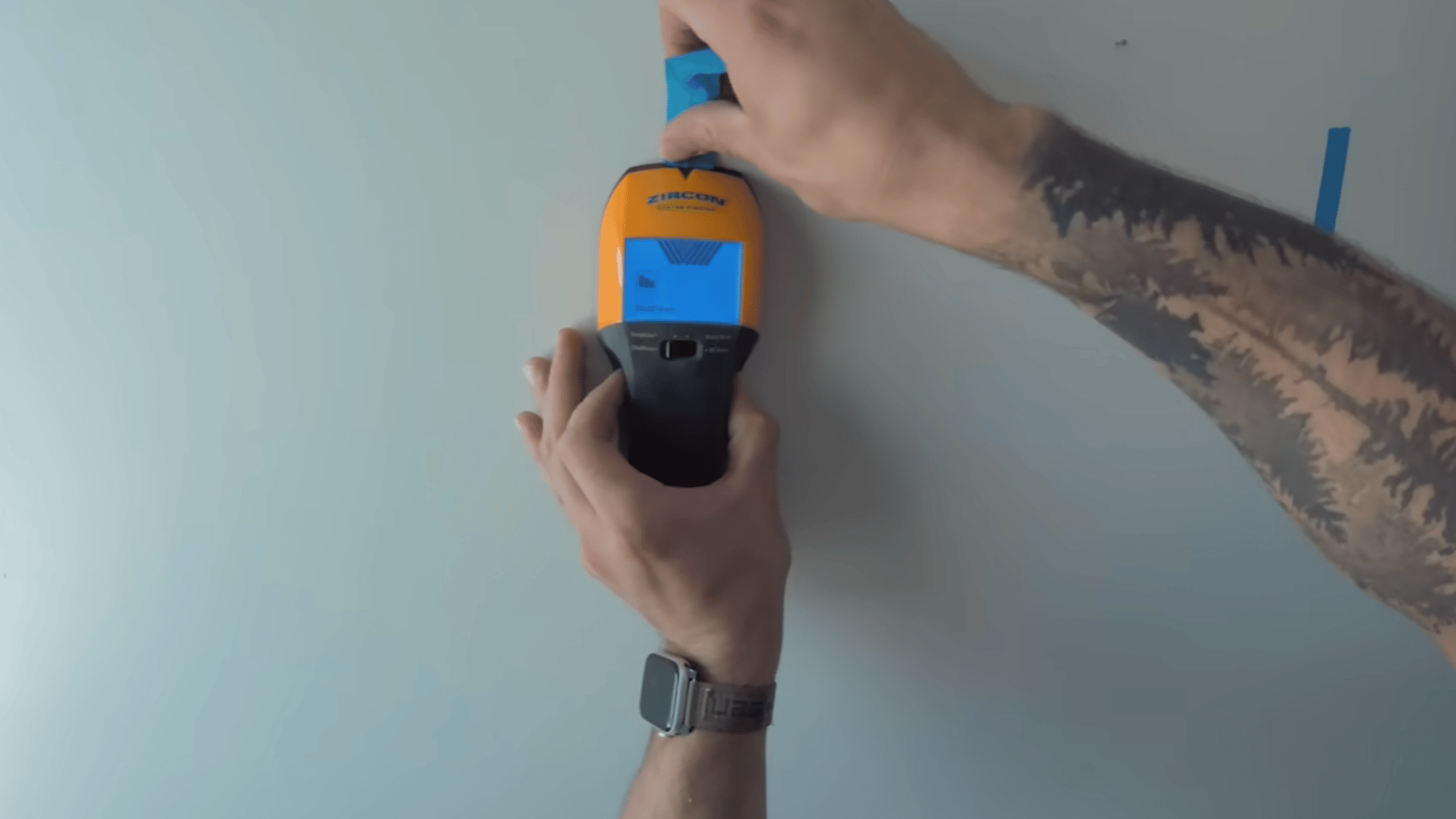 hands using a stud finder on the wall while making final checks for the built-in bunk bed