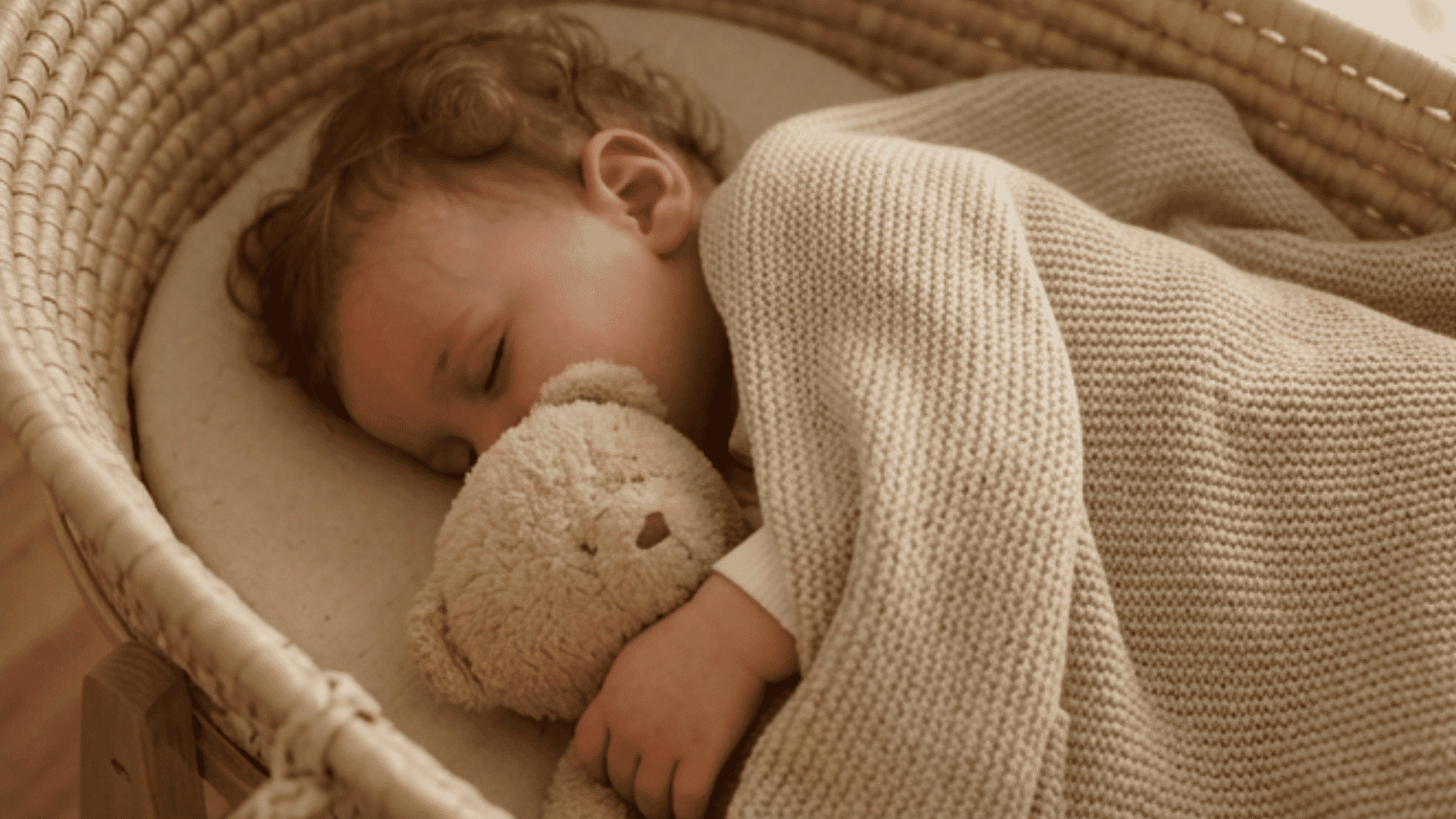 sleeping toddler holding teddy bear in cozy bedroom setting