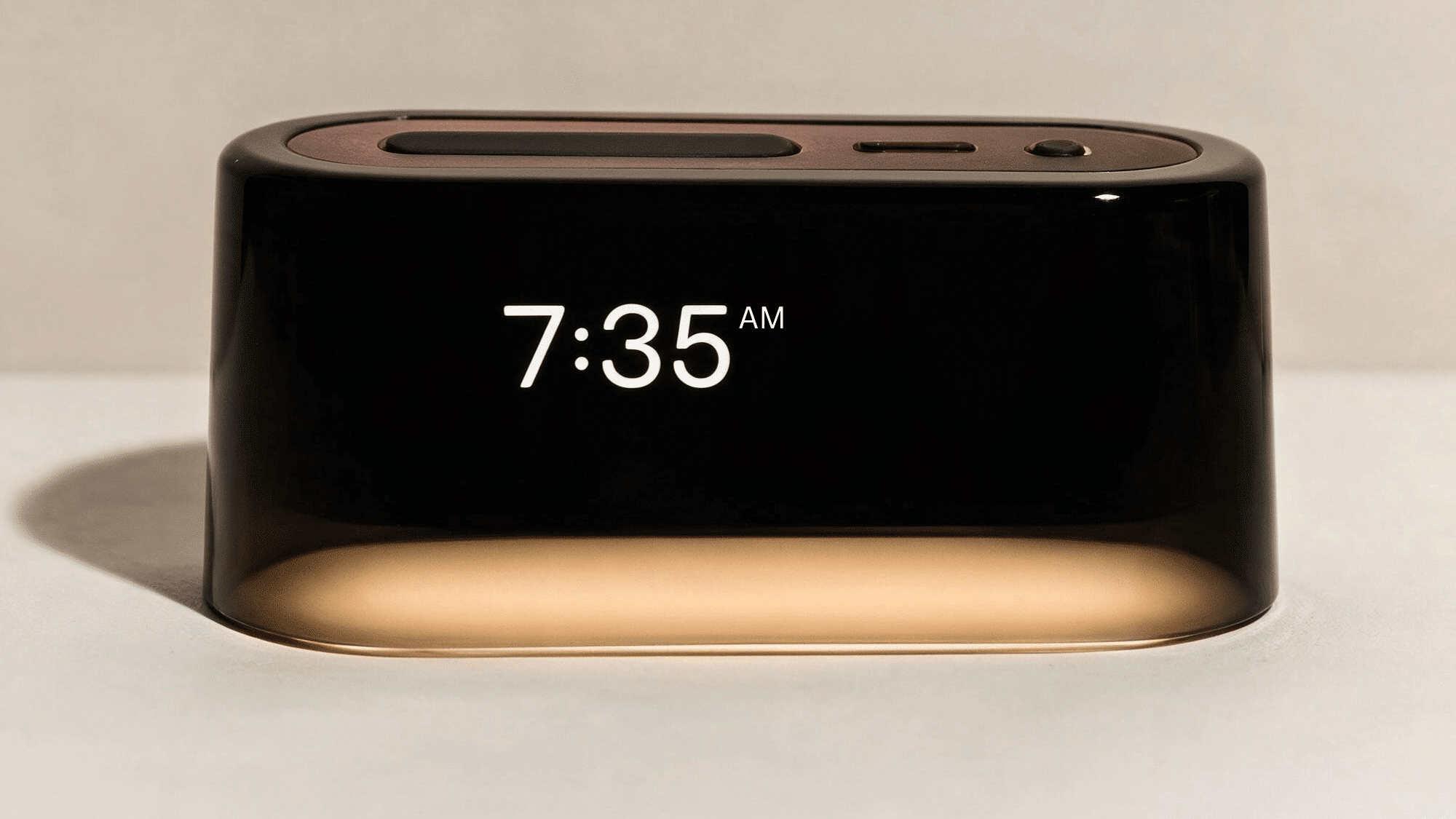 loftie clock sleep device with digital display, compact rectangular design, and illuminated base on a clean background