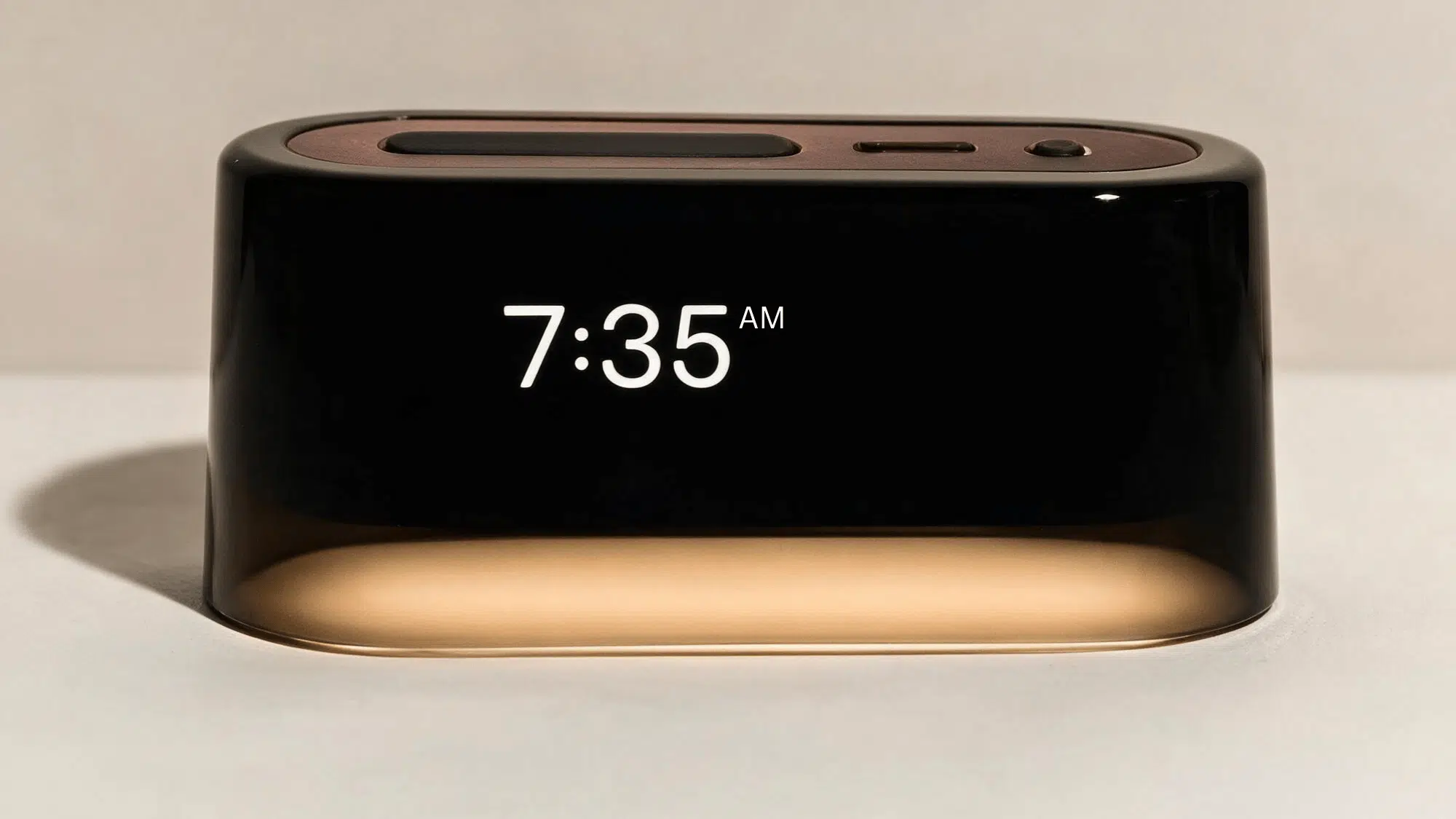 loftie clock sleep device with digital display, compact rectangular design, and illuminated base on a clean background