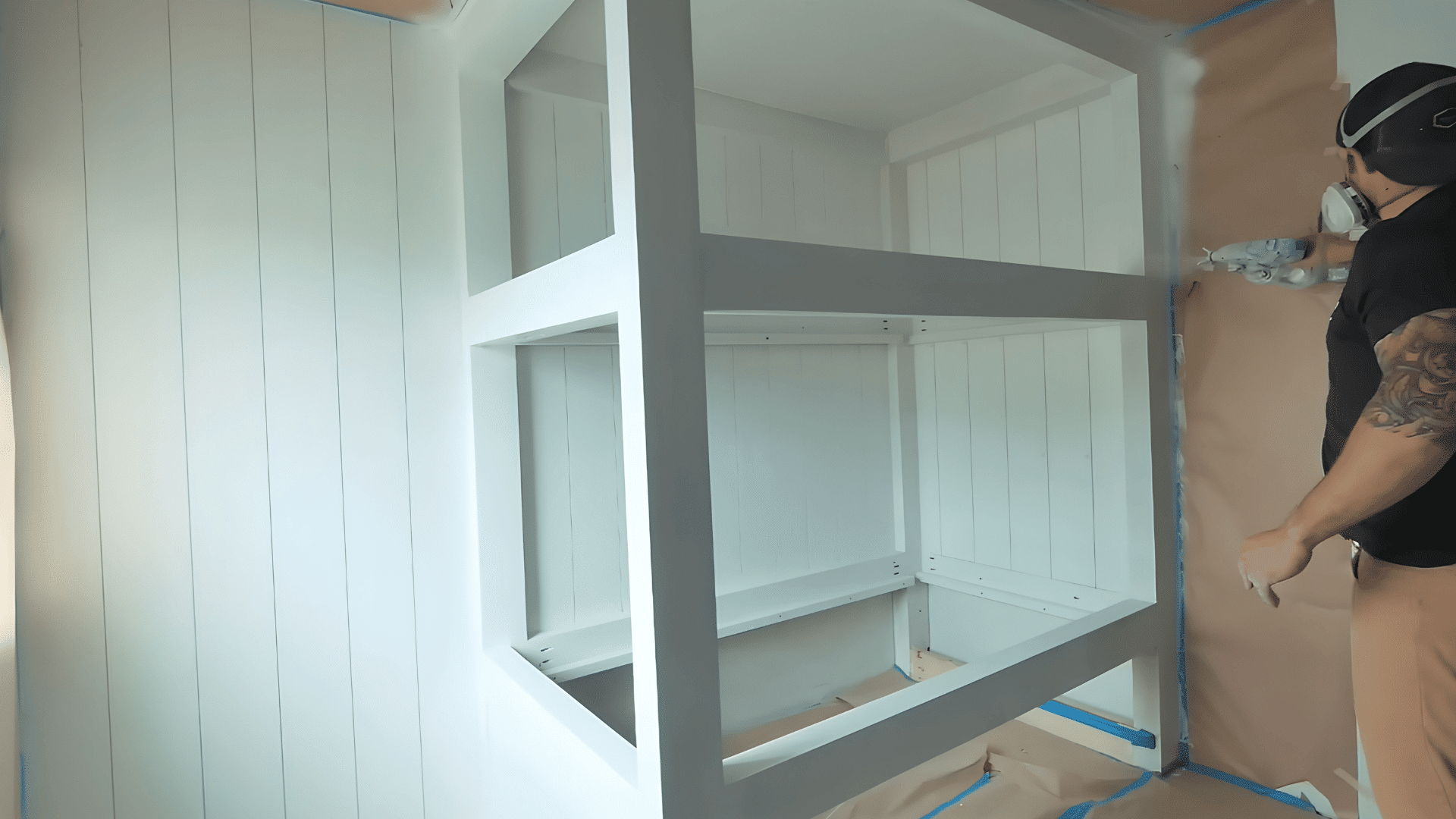 man checking lumber and tools while preparing materials for a large built-in bunk bed