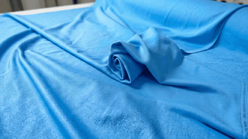 Blue polyamide fabric folded to show soft texture and smooth textile surface.