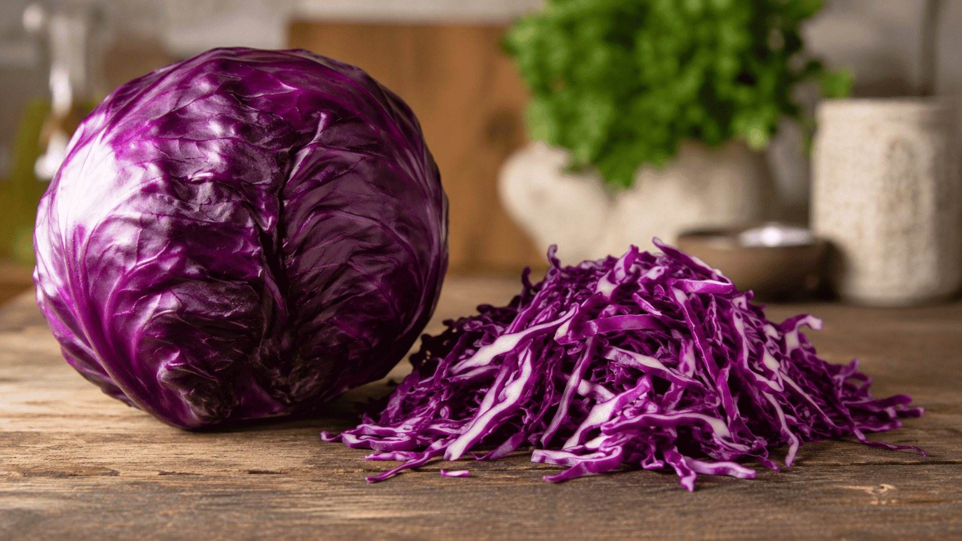 whole and shredded red cabbage arranged on a rustic wooden table