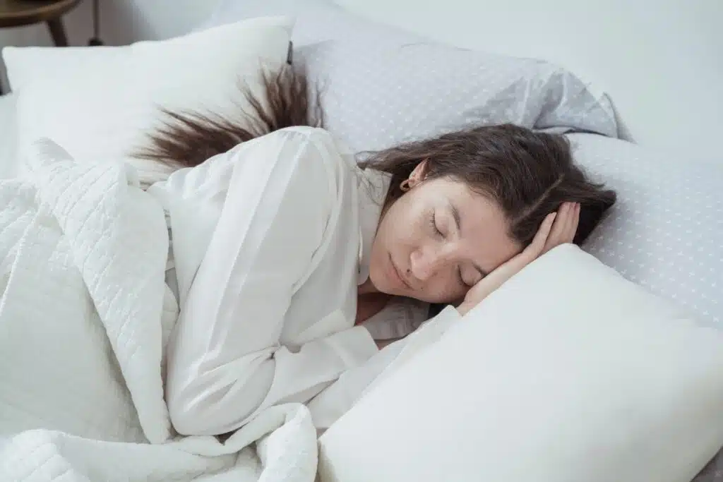 Woman sleeping on a comfortable mattress in a cozy bedroom