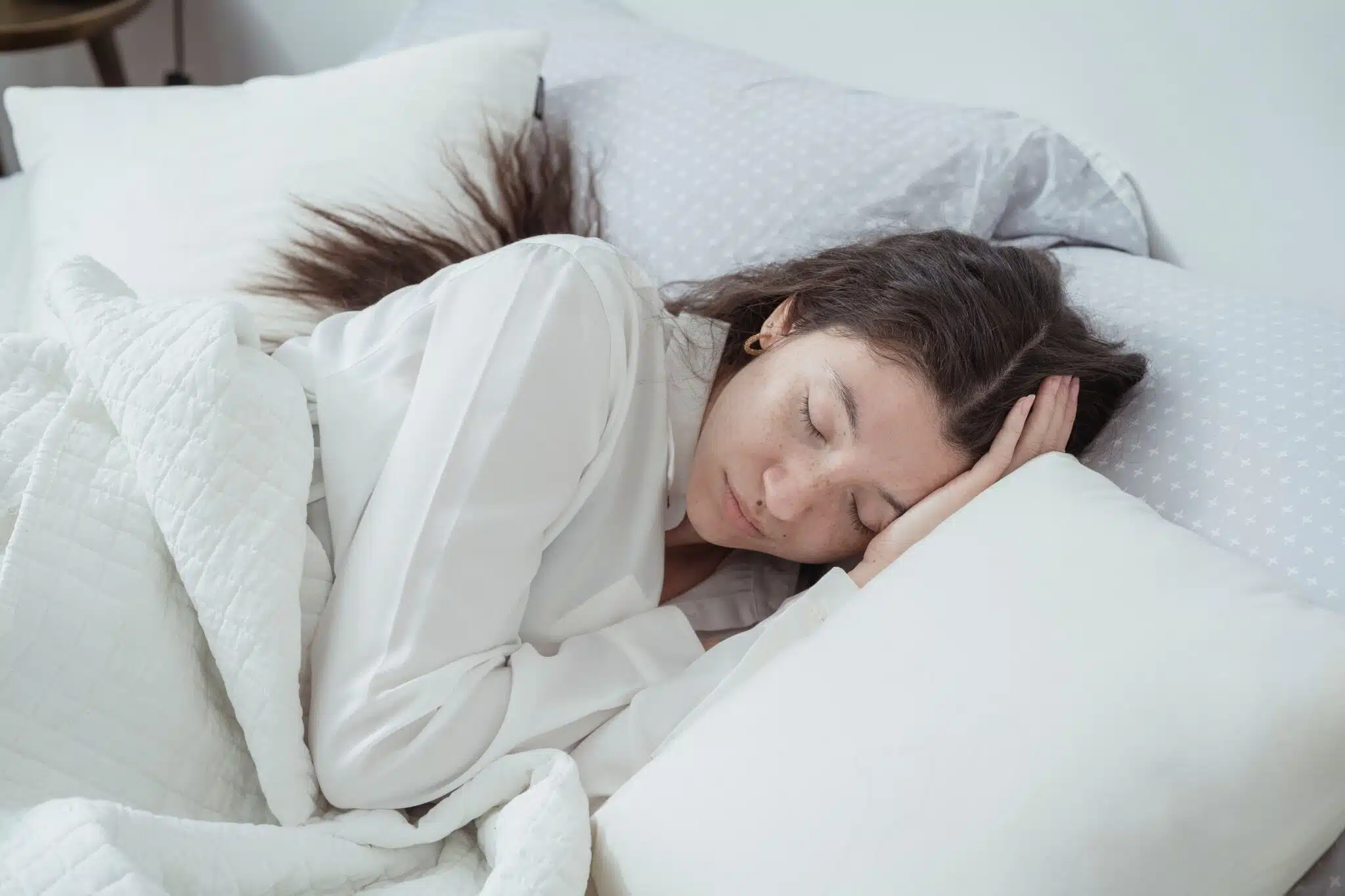 Woman sleeping on a comfortable mattress in a cozy bedroom