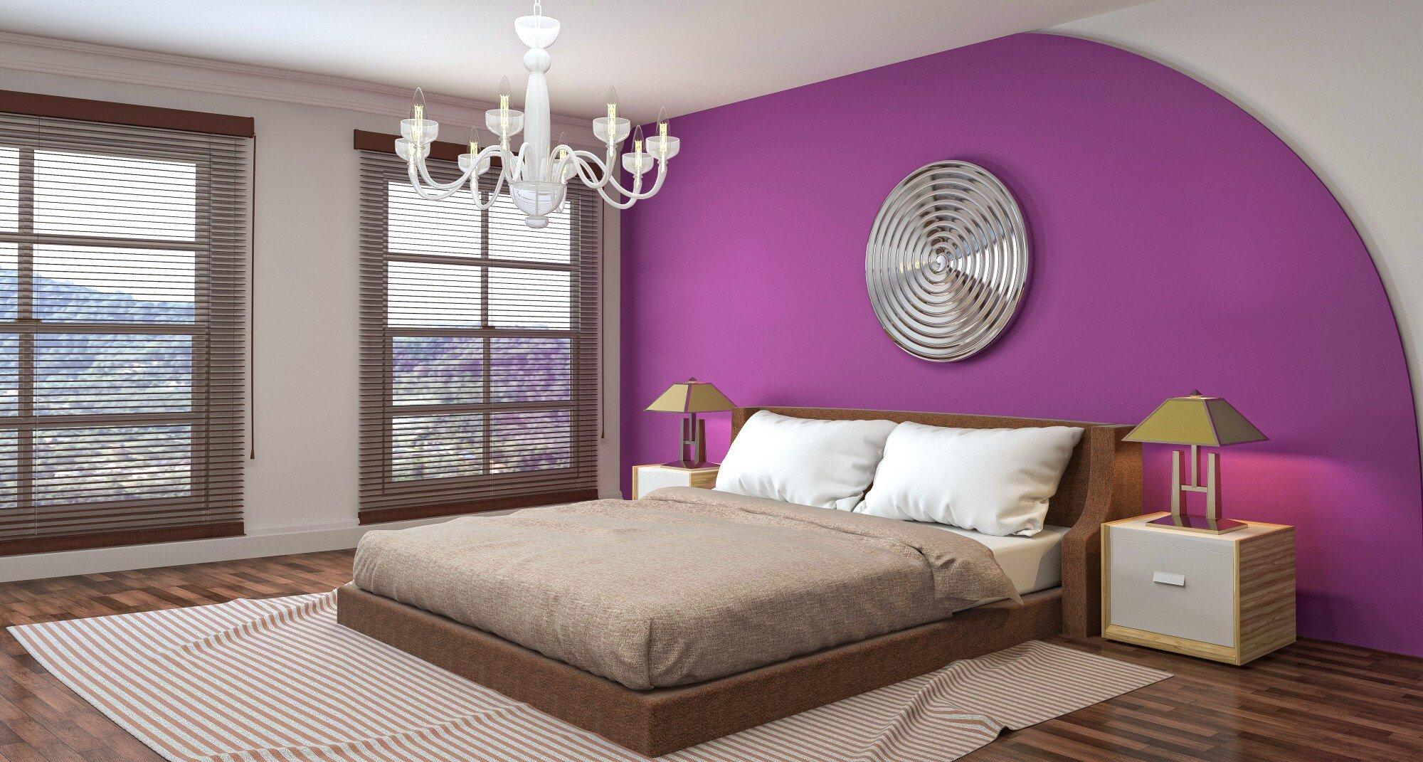 Modern bedroom with purple accent wall, wooden bed, and decorative chandelier lighting